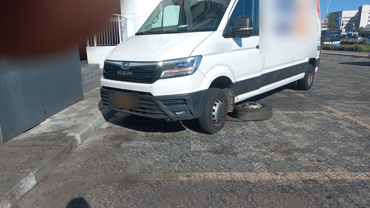 ואן מסחרי שעומד בחניה בתל אביב עם גלגל קדמי מפורק לפני החלפה