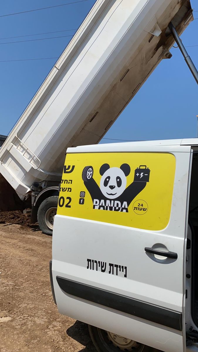 דלת ניידת השירות של פנדה עם הלוגו, ליד משאית רכינה